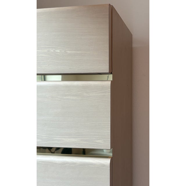 This striking five-drawer chest features a clean, architectural silhouette accented by horizontal mirrored insets between...