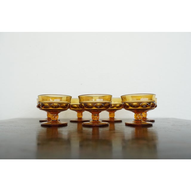 This vintage set of seven amber glass sherbet glasses by Indiana Glass features the classic King’s Crown (Thumbprint)...
