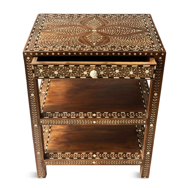 Handcrafted in India from richly toned teak, this vintage bedside table showcases exquisite hand-laid inlay work with...