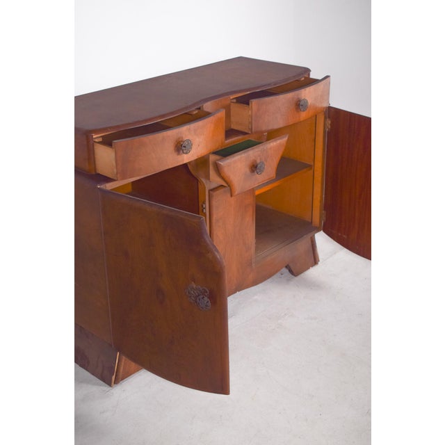Art Deco sideboard. In medium-toned wood with a satin finish, it has a warm and sophisticated look, with rich natural...
