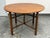 Design Plus Gallery presents an Antique Burmese Folding Table. This circular wooden table showcases a rustic design with a...