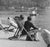 1982 photo of people on the shored of the Serpentine lake at Hyde Park in London. The photo focuses on a young man sunning...