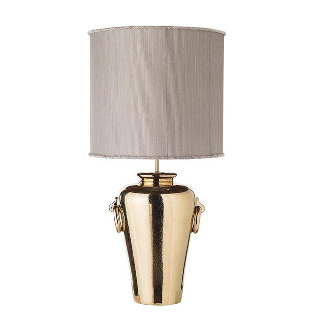 Table lamp with decorative rings and shades. The majestic ceramic shaped body of the lamp is emphasized by two decorative...