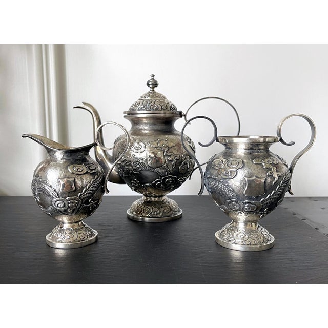 A three-piece set of Chinese export sterling silver tea or coffee service circa early 20th century. The service consists...