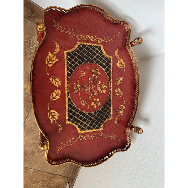 Elegant hand-painted tray table by Dessau Home, featuring intricate gold gilt detailing, scalloped edges, and a removable...