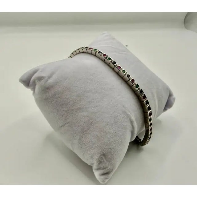 A refined Art Deco style tennis bracelet crafted in pure sterling silver , featuring a vibrant sequence of round-cut...