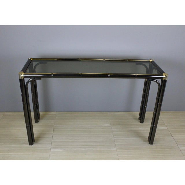 Vintage faux bamboo metal console in a pewter finish with brassplated fitting and smoke glass top Dimensions: 47"Width x...