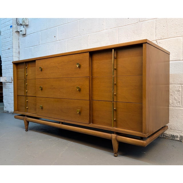 This quintessential mid-century modern triple dresser features a warm, rich walnut finish and a signature "floating"...