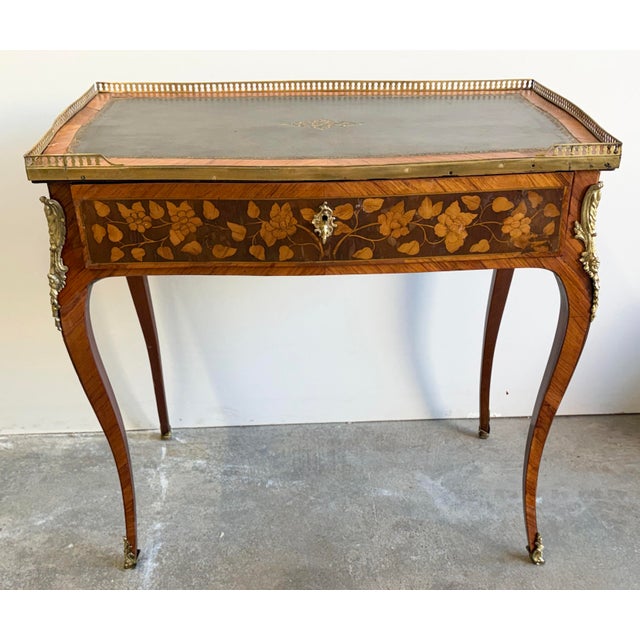 French Louis XV writing desk with a embossed leather top surrounded by pierced gallery trim along with cabriole legs...