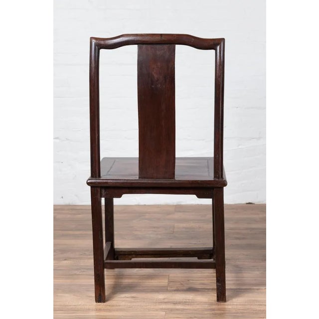 A set of four antique Chinese elmwood scholar's ceremonial side chairs from the early 20th century, with dark patina and...