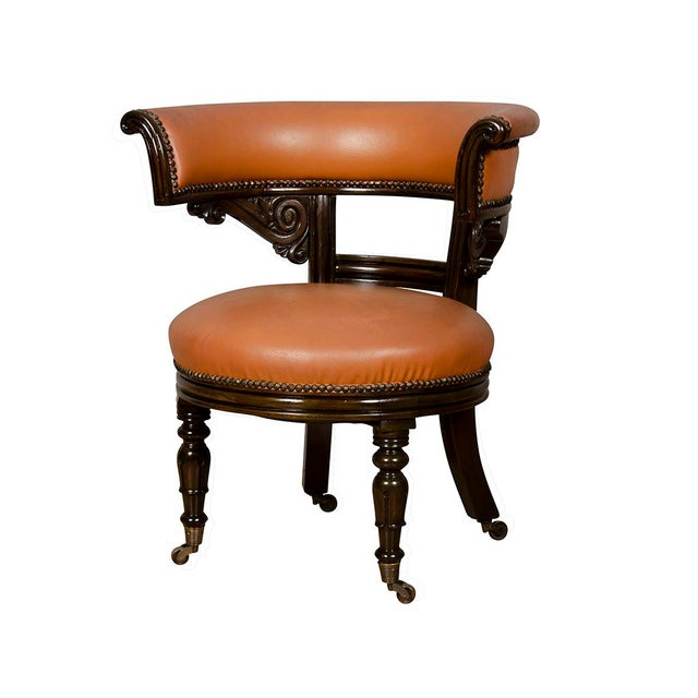 With U shaped backs and circular seats upholstered in brown leather , the backs with carved frames raised on turned legs...