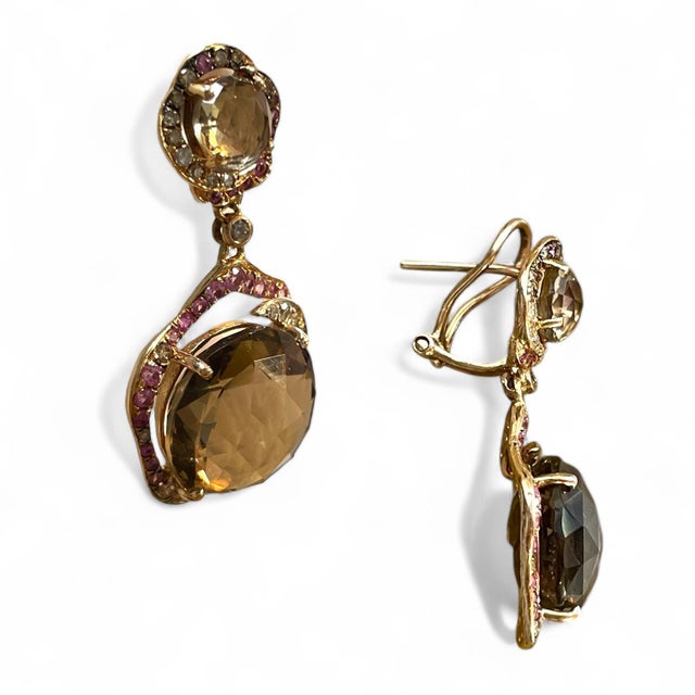 These elegant 14K yellow gold dangle earrings feature large, faceted smoky quartz gemstones framed by vibrant pink and...