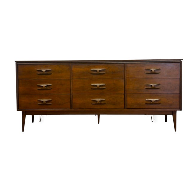 Crafted in warm walnut tones, this authentic mid-century lowboy dresser by Bassett Furniture features a clean-lined...