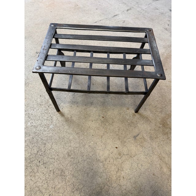Substantial handmade wrought-iron fireplace trivet or kettle stand featuring traditional hand-worked construction and an...