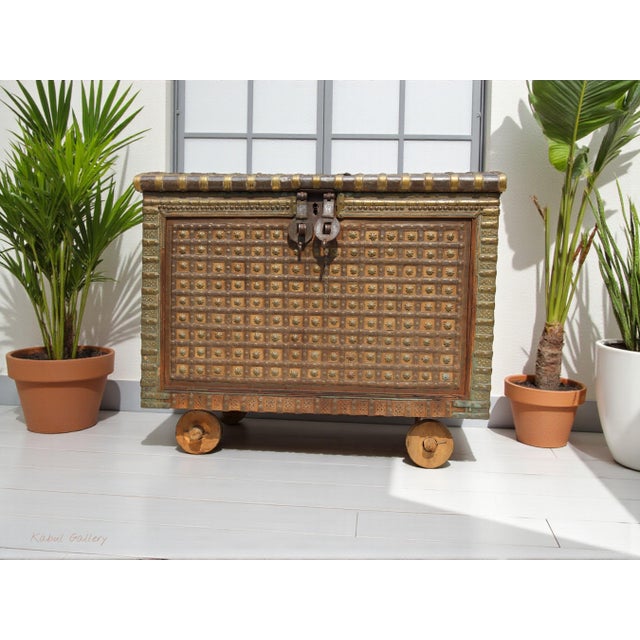 Indian Dowry Chest on Wheels. A large Indian metal-bound dowry chest on wheels, with an arched top featuring dual heavy...