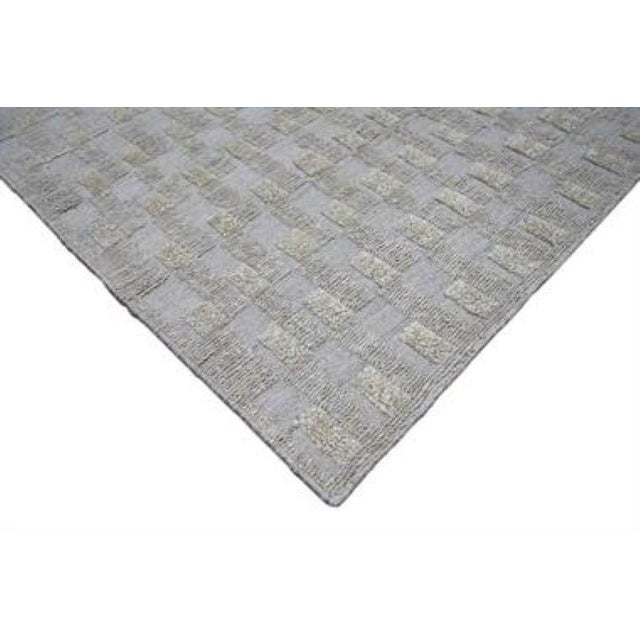 This loom knotted cotton & Wool Rug features a geometric pattern with multi colors, creating an eye-catching example that...