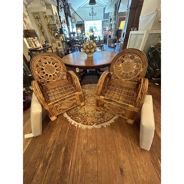 Eye poppingly dramatic large lacquered rattan bamboo club chairs having ornate design that leave a lasting impression....