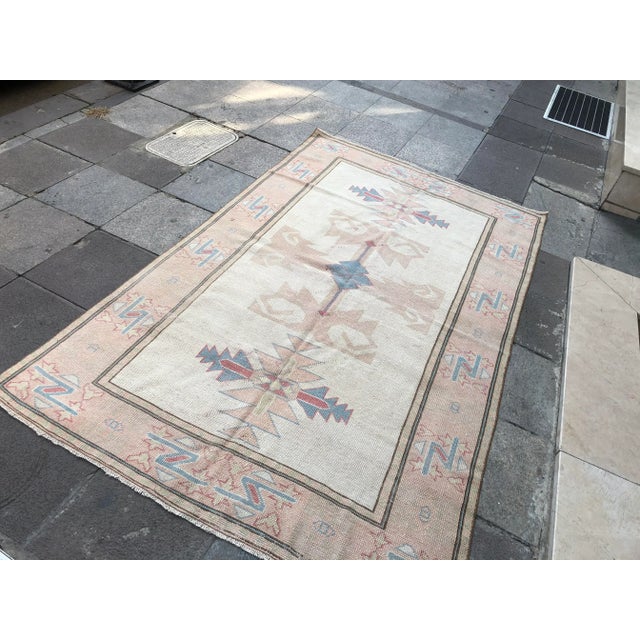 This is a vintage Turkish Oushak rug from the 1960s. The piece was hand-knotted.