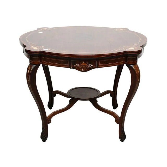 This antique English Rosewood center table features a string inlay with flowers, adding a touch of elegance to any room....