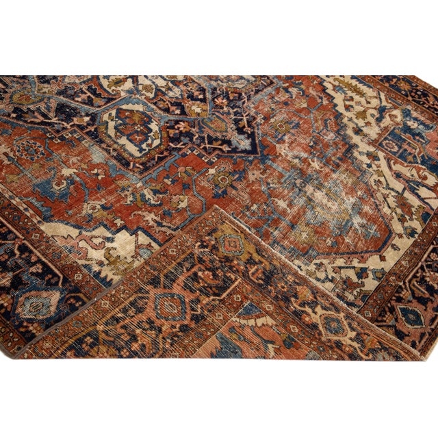 Beautiful antique Heriz hand-knotted wool rug with a rust color field. This Persian rug has multicolor accents in a...
