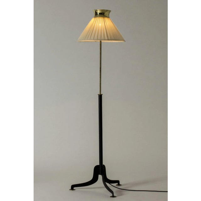 Beautiful, rare floor lamp by Josef Frank, made from black lacquered metal and brass. Distinctly sculpted base, pleated...