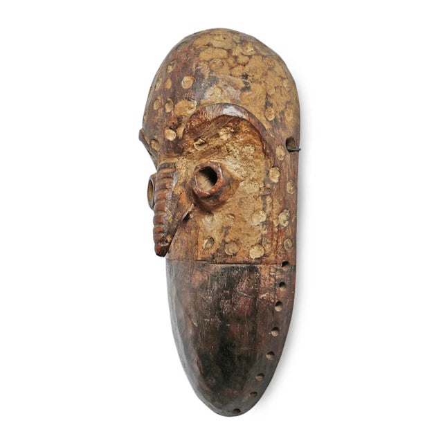 Vintage carved wood Lega wood mask from Democratic Republic of Congo. Ridged stripes on nose and indented circular dot...
