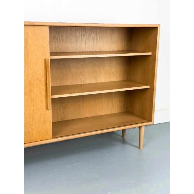 Exceptional oak highboard with a variable sliding door that conceals either the right or left shelf section. A clever...