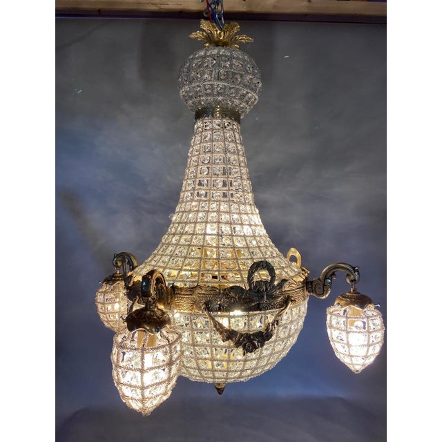 A decorative late 20th century French Louis XVI style chandelier, beautifully finished in warm gold and designed with...