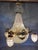 A decorative late 20th century French Louis XVI style chandelier, beautifully finished in warm gold and designed with...