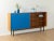 A wonderful sideboard from the 1960s. The body is made of teak veneer with two cabinet doors, four shelves, and new black...