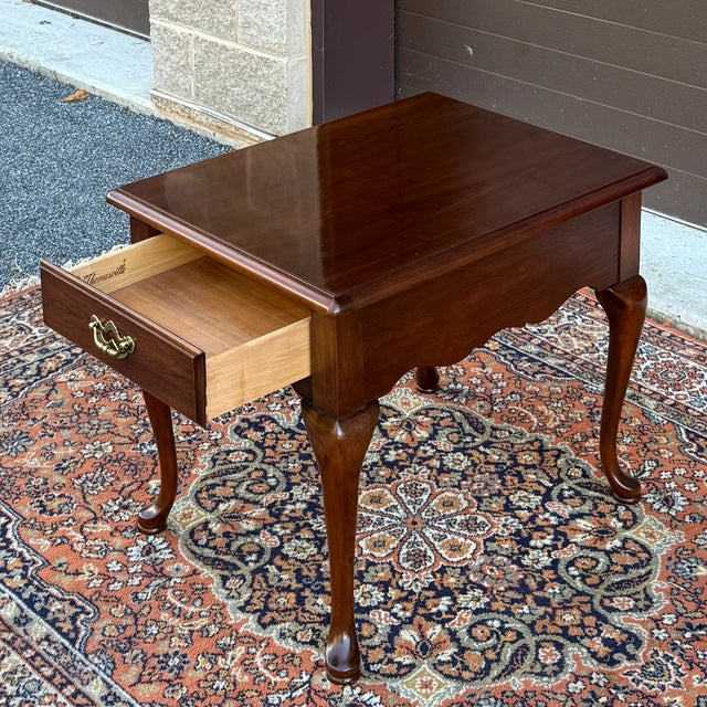 A vintage Thomasville Collector's Cherry Traditional Queen Anne side table with one dovetailed drawer and polished brass...