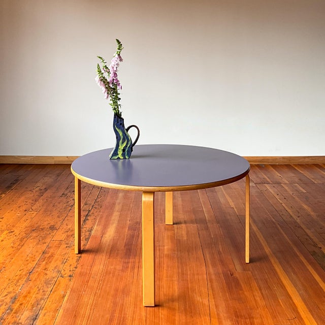 Styled after Artek’s Aalto table 90A. This is a round coffee or children’s table with a periwinkle colored linoleum top...