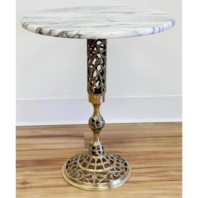 Classic vintage French style brass filigree base table with round marble top. Marble features gorgeous veining. Versatile...