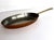 A fine antique French oval copper sauce pan featuring a sturdy brass handle secured with traditional copper rivets....