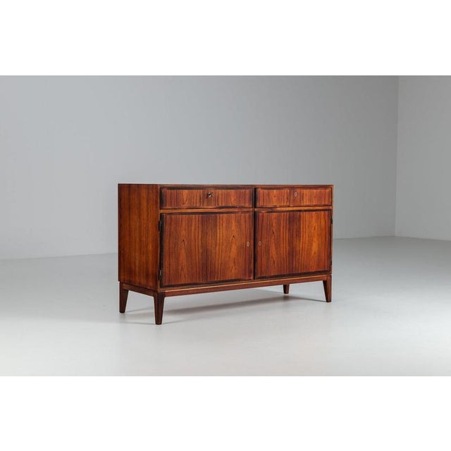 Striking Model 5 sideboard, designed by Gunni Omann and produced by Omann Jun in Denmark in the 1960s. It is a fine...