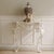 The console table is a newly produced piece of furniture featuring a bevelled wooden top and an openwork metal frame made...