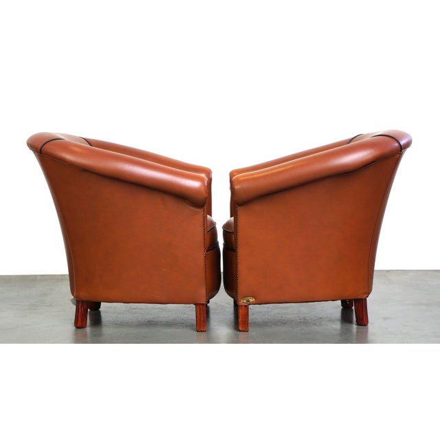 This attractive set of cowhide club armchairs comes from England and has a warm appearance, partly due to their color....