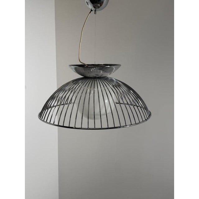 Striking vintage space age pendant lamp by the iconic Harvey Guzzini aesthetic. This elegant suspended lamp features a...