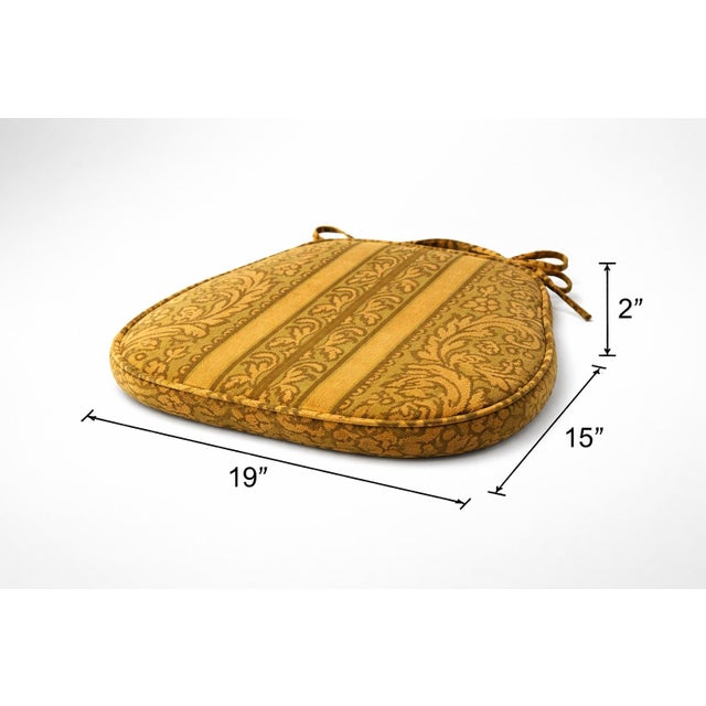 A charming pair of vintage upholstered chair seat cushions featuring a classic damask stripe pattern in warm gold and...