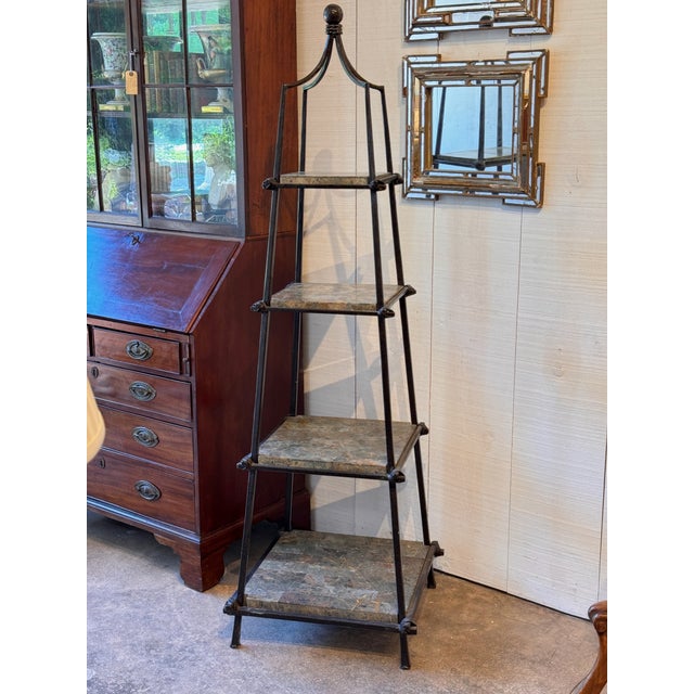 A striking obelisk-form etagere in dark metal with four stone shelf tiers graduating in size from bottom to top, topped...