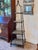 A striking obelisk-form etagere in dark metal with four stone shelf tiers graduating in size from bottom to top, topped...