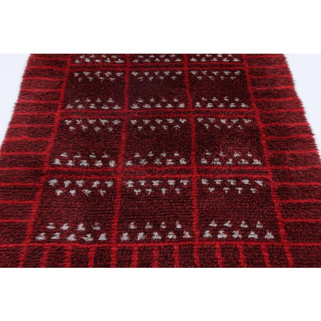 Hand-knotted in lush, high-pile wool in Sweden circa 1960-1970, this 4x6 vintage Swedish Rya rug is a bold new addition to...