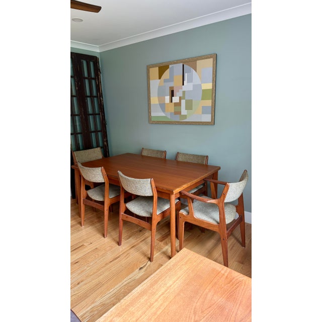By Scandinavia Woodworks Co. featuring warm teak grain and 6 dining chairs- 4 side chairs and 2 with arms. The main table...