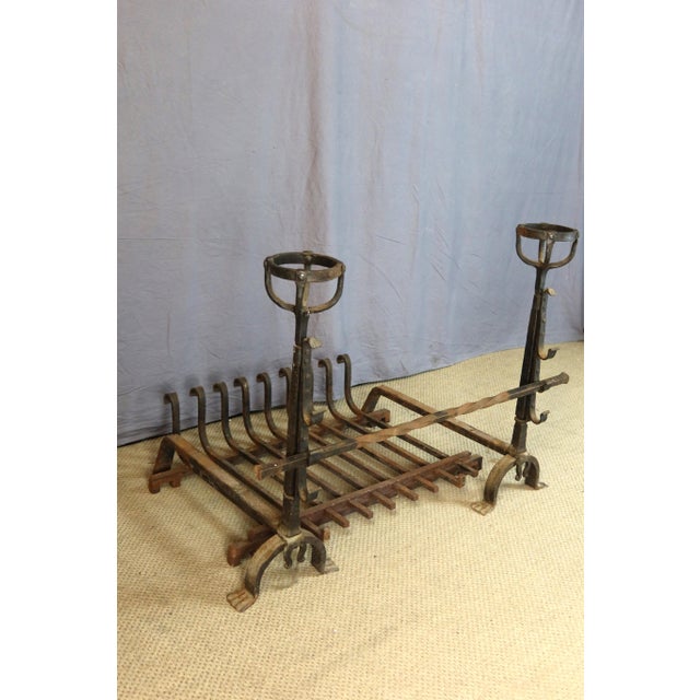 Pair of large wrought iron andirons, known as "bowl andirons," with adjustable spit bars and a fireplace grate. Very good...