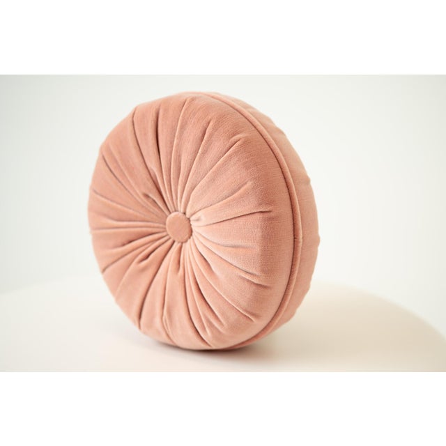 Soft and romantic, this round blush pink throw pillow features a gathered, smocked center that adds charming texture and...
