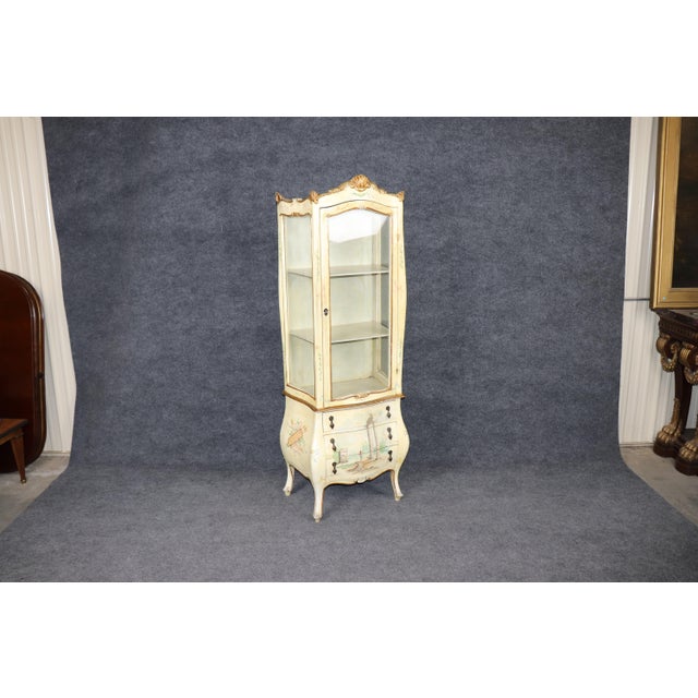 Bring timeless European charm into your home with this exquisite Italian paint-decorated bombe style vitrine, a stunning...