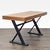 This Moe's desk features a sturdy solid wood top with a natural finish and strong black metal legs in an industrial...