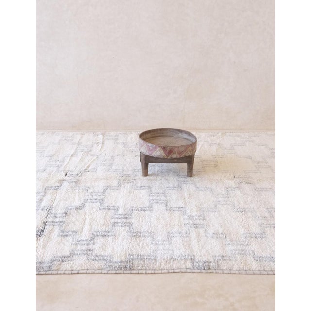 This exquisite White Moroccan Mrirt Rug, handwoven with meticulous care, measures 10 by 6.8 feet. Its elegant design and...