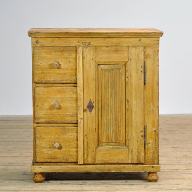 This pine cabinet dates from the early 20th century and is crafted from characteristic, weathered pine. Its warm, honey-...