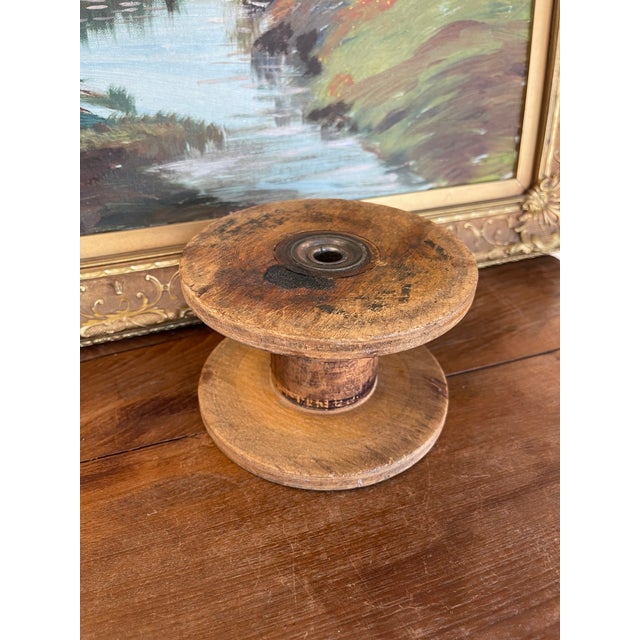 This likely antique industrial wooden spool originates from an early textile mill and showcases the utilitarian...